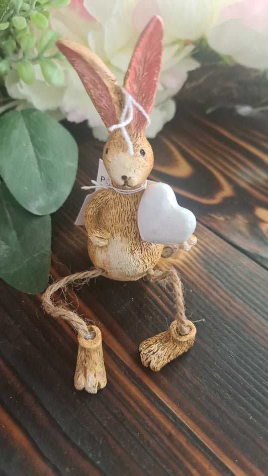 Brown dangling leg bunny holding heart